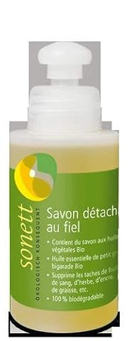 Petit flacon de savon détachant liquide posé sur du lin écru dans une buanderie