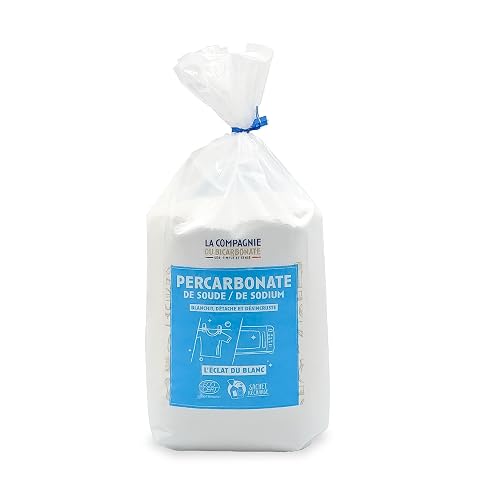 Poudre blanche de percarbonate de soude dans une coupelle en céramique sur du lin écru