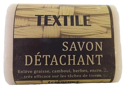 Trois pains de savon détachant au fiel de bœuf posés sur du lin dans une buanderie sobre.